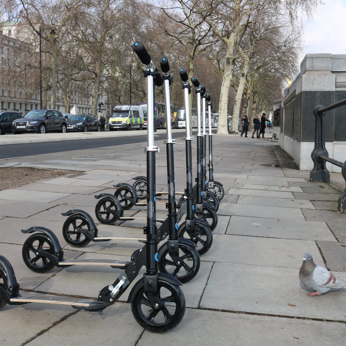 Electric Scooters on London Sidewalk with Pigeon