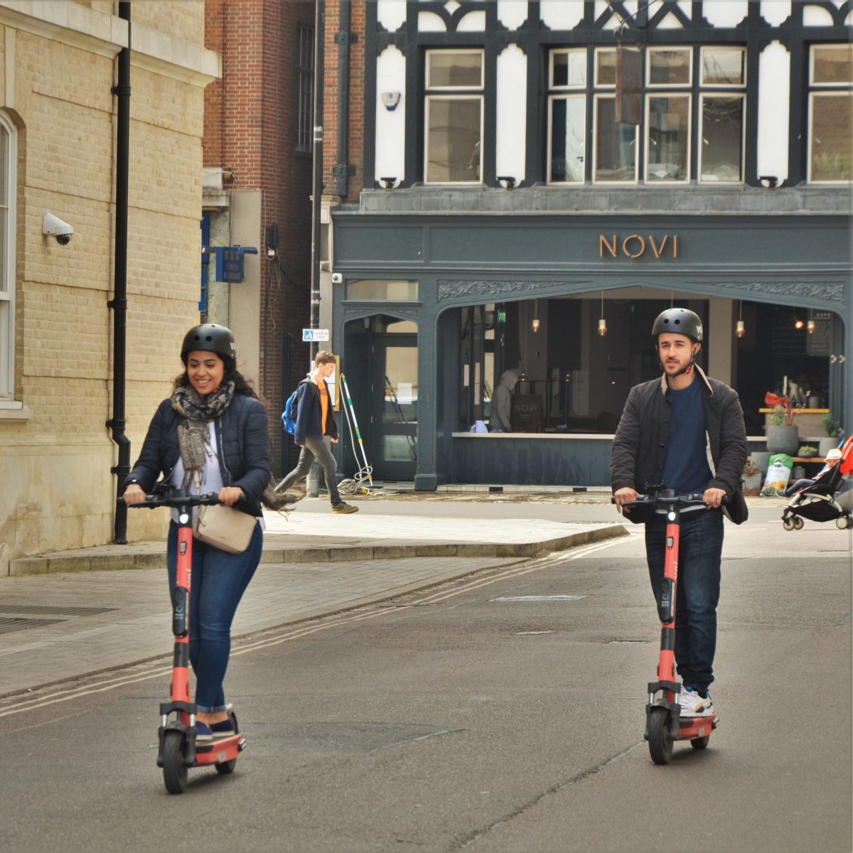 a young boy riding a skate board on a city street