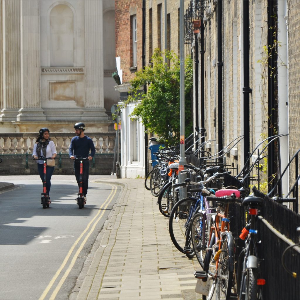 a group of people walking down a street next to a bicycle